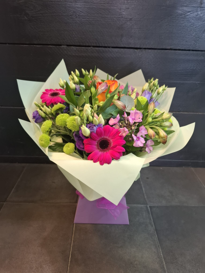 Petal Paradise - A lively bouquet featuring a bright mix of vibrant seasonal blooms. Complemented by lush green foliage and presented in a beautiful packaging, this arrangement is perfect for adding a pop of colour to any occasion