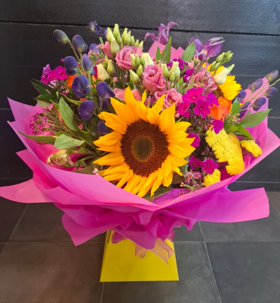 Bright Ideas - Beautiful Sunflowers and a peppering of other summer flowers and foliage. Tied in water and presented in a stylish bag. An amazing bouquet full of joy and delight ready to display and enjoy.